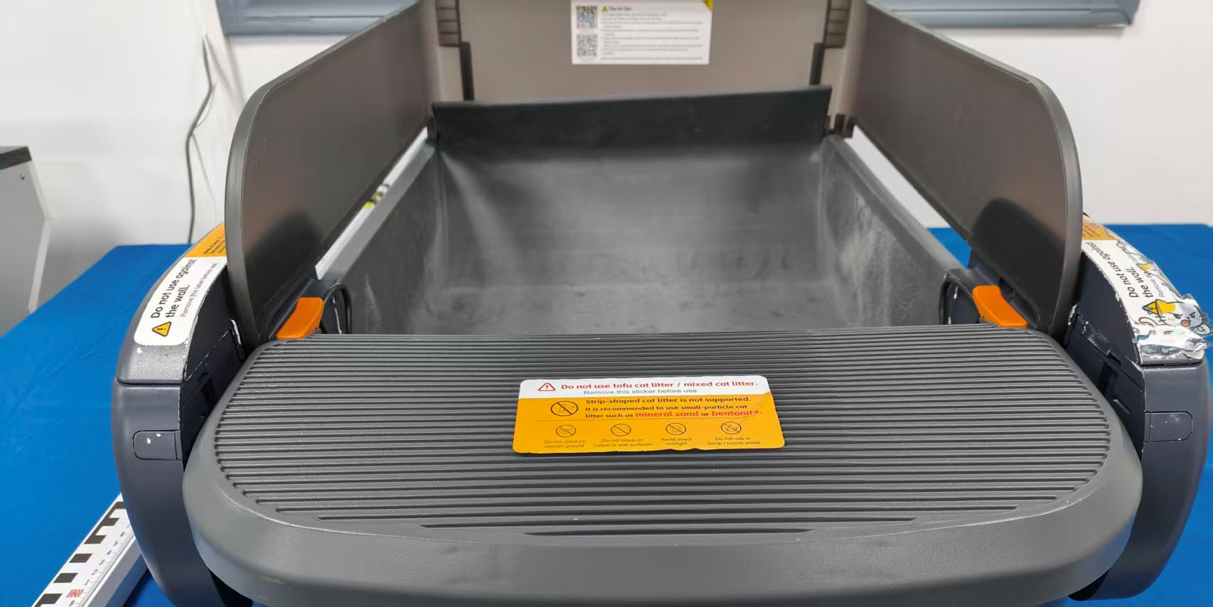 Front view of the photographed ABRCT Automatic Cat Litter Box Ease FCC sample, an uncovered gray tray with side guards and a front step.